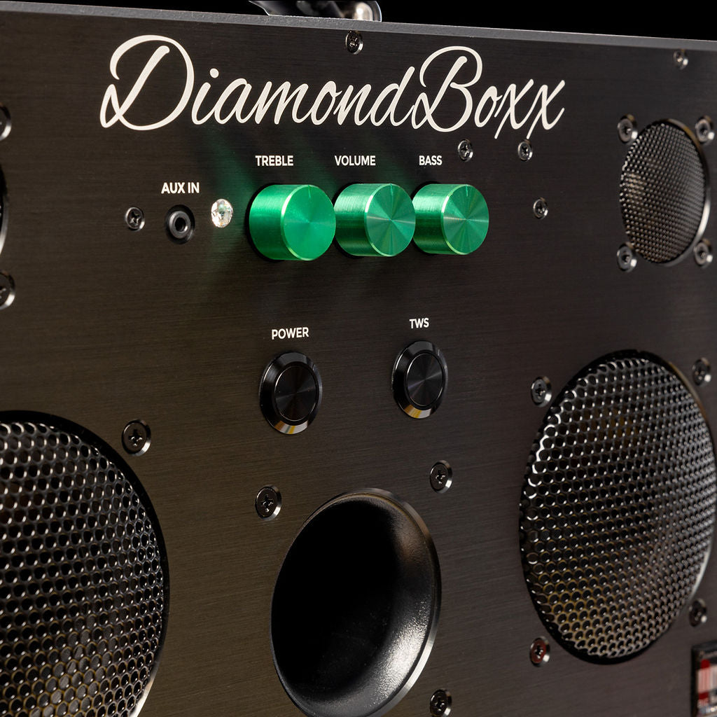 zoomed in view of diamondboxx logo, power, and tws buttons on the front of black M3 speaker with green knobs