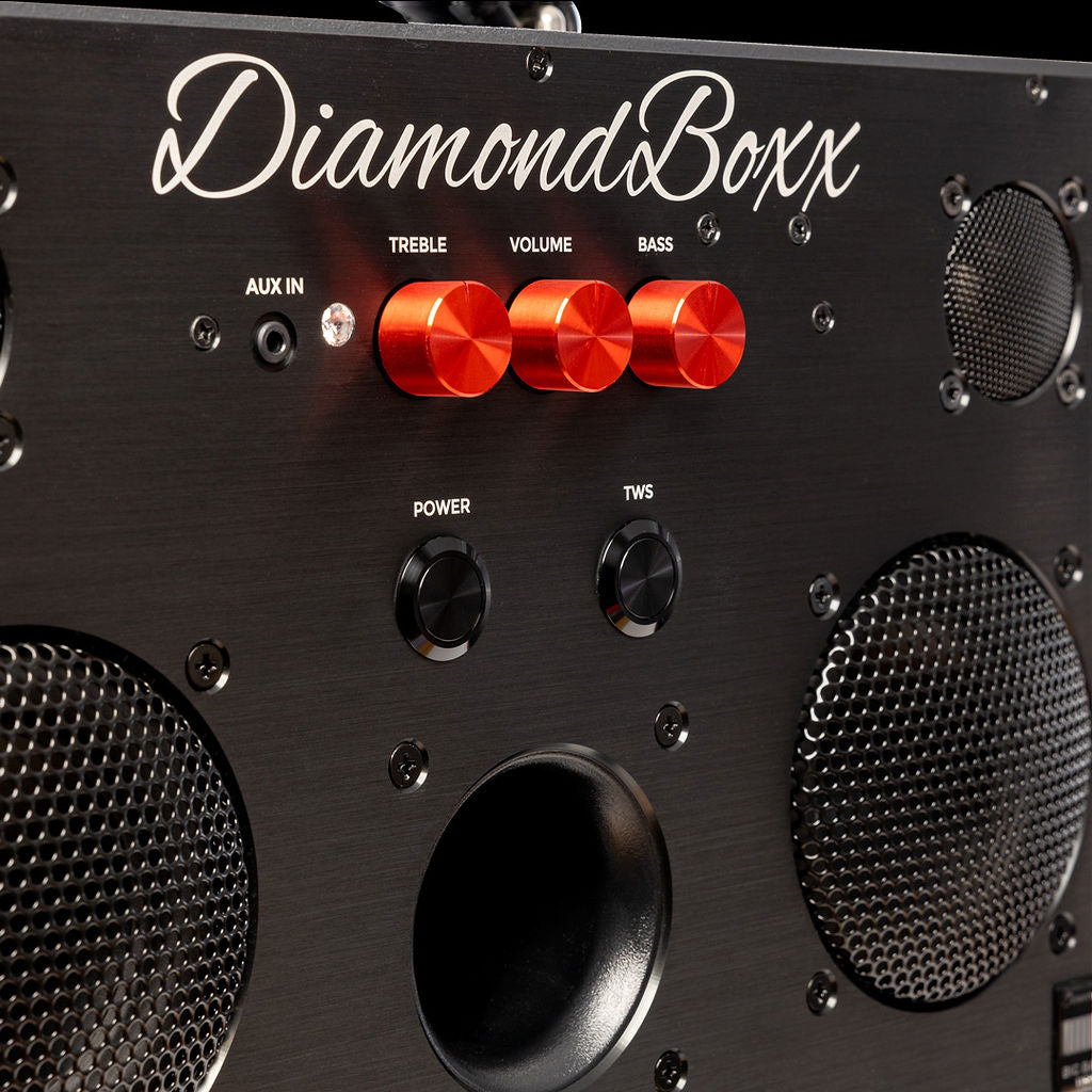 zoomed in view of diamondboxx logo, power, and tws buttons on the front of black M3 speaker with red knobs